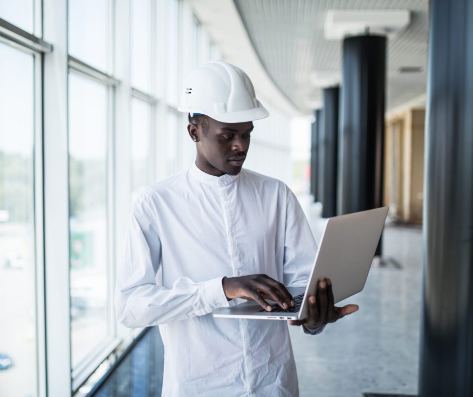African american architect working with computer and blueprints in office